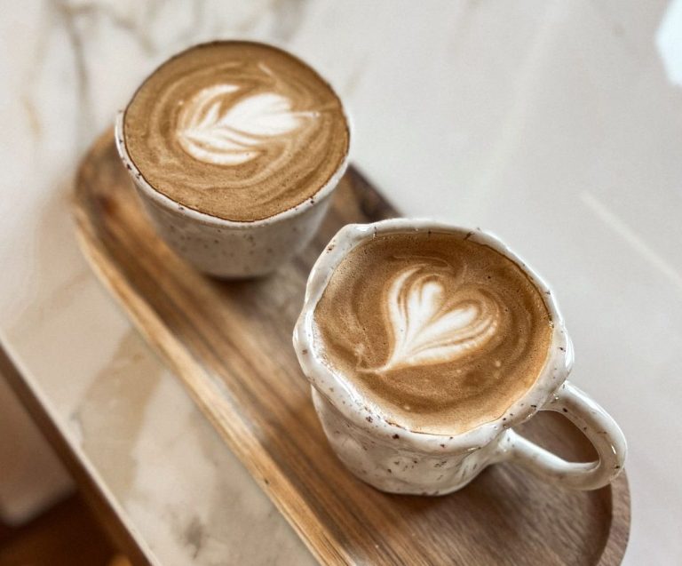 Cappuccino in handgefertigten Tassen auf Holztablett – kreative Pause im Form-Atelier Ein Moment der Ruhe – handgemachte Keramiktassen laden zum bewussten Genießen ein.